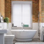 There are some fabulous and realistic looking faux wood blinds available  which have the look of real wood but are suitable for bathrooms and  kitchens.