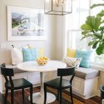 Round table and corner banquette dining area | bright pillows