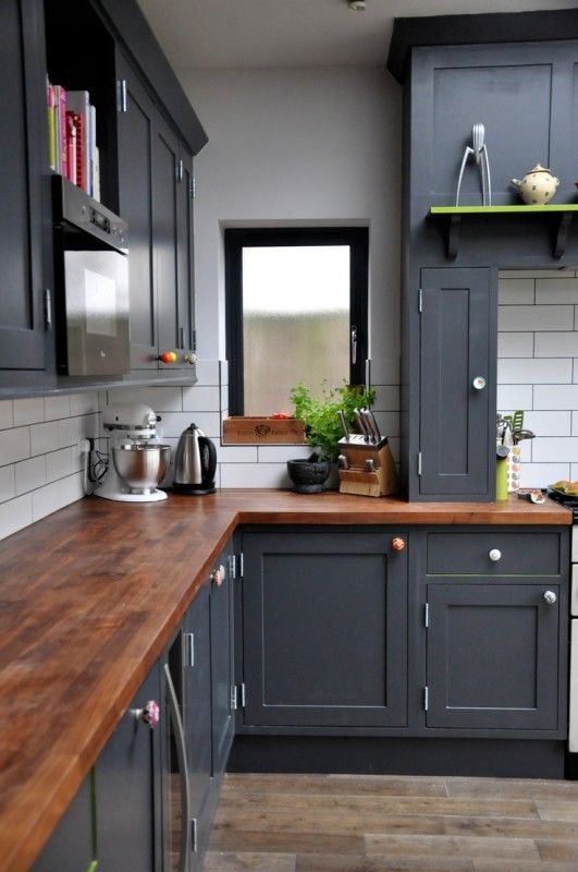 black kitchen cabinets with colorful knobs and wood countertops