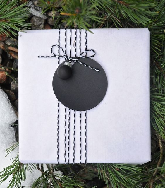 white wrapping with a chalkboard gift tag and a tiny ornament