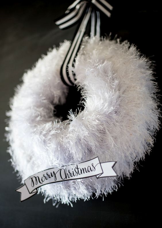 a fluffy white wreath with a striped ribbon