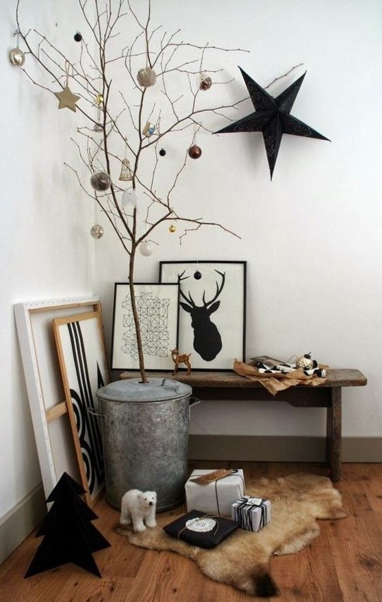 a Nordic entryway space with some artworks, branches with ornaments and a large black star on the wall