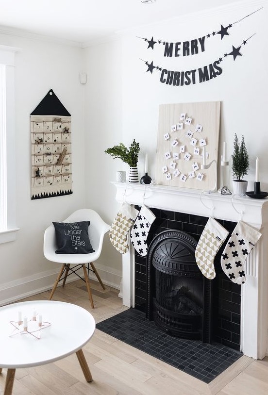 a black letter banner, a black and white advent calendar, black and white printed stockings and black candleholders with white candles