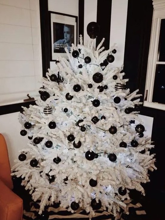 a crispy white Christmas tree with black matte and glossy ornaments and lights is a cool and fresh idea for a modern space