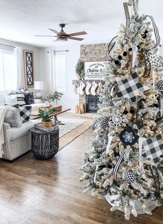 a flocked Christmas tree with lights, buffalo check stars, ornaments and garlands and snowflake ornaments is awesome for a farmhouse space