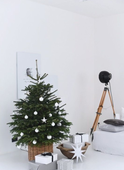 a minimalist Scandi Christmas tree with white baubles and stars placed into a basket is a lovely and fresh solution