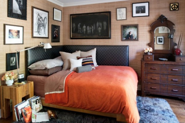 an eclectic sleeping space with a dark stained sideboard and mirror, a black leather bed, a rustic nightstand and a huge gallery wall all over