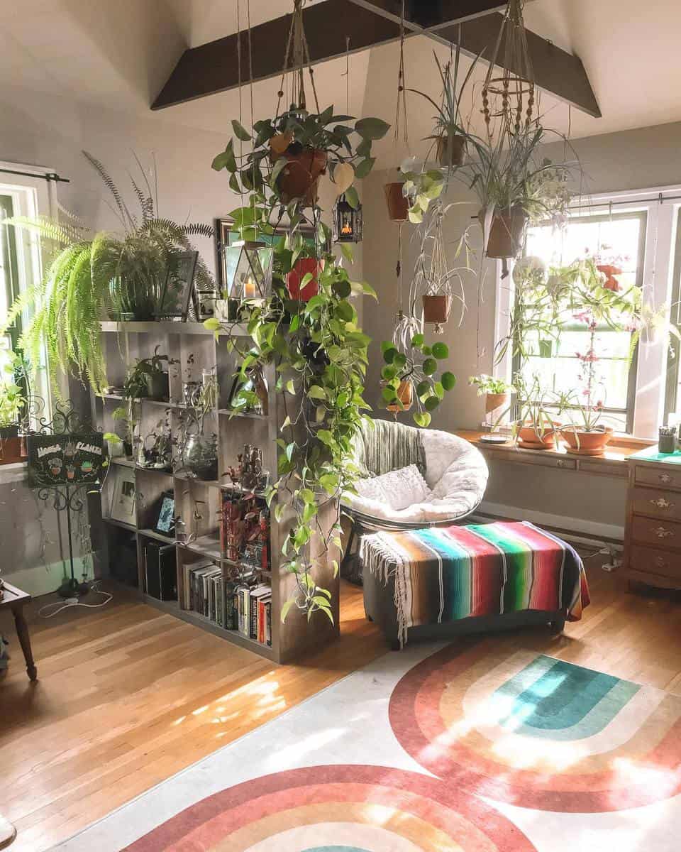 Small living space with lots of plants and bookshelf divider