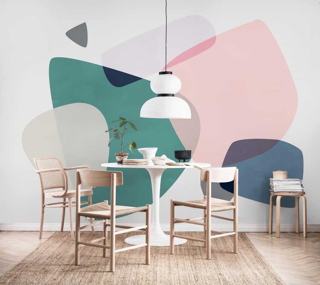 Abstract colored photo wallpaper, small dining table and wooden chairs 
