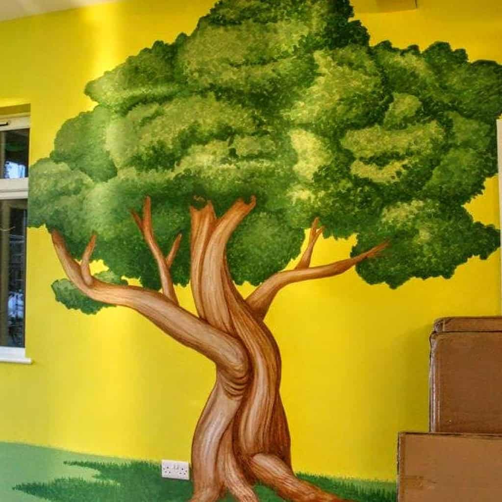 Tree mural painted on yellow exterior wall 