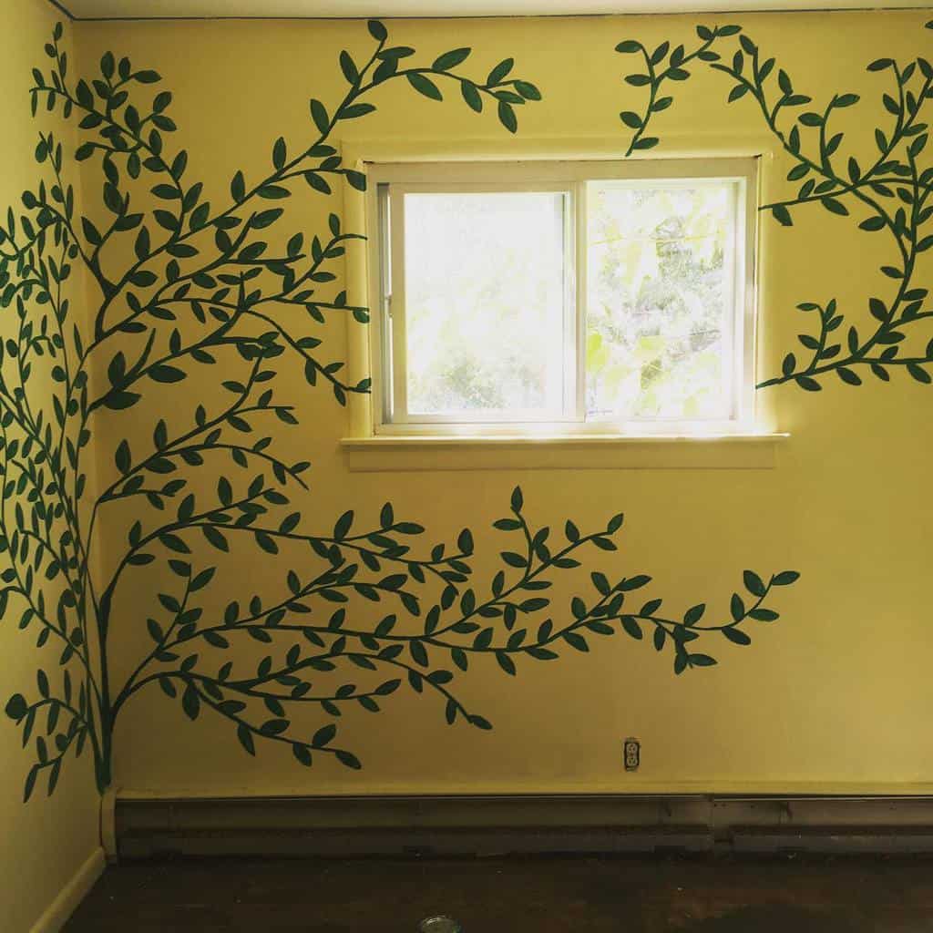 Yellow walls with hand painted green tree mural 