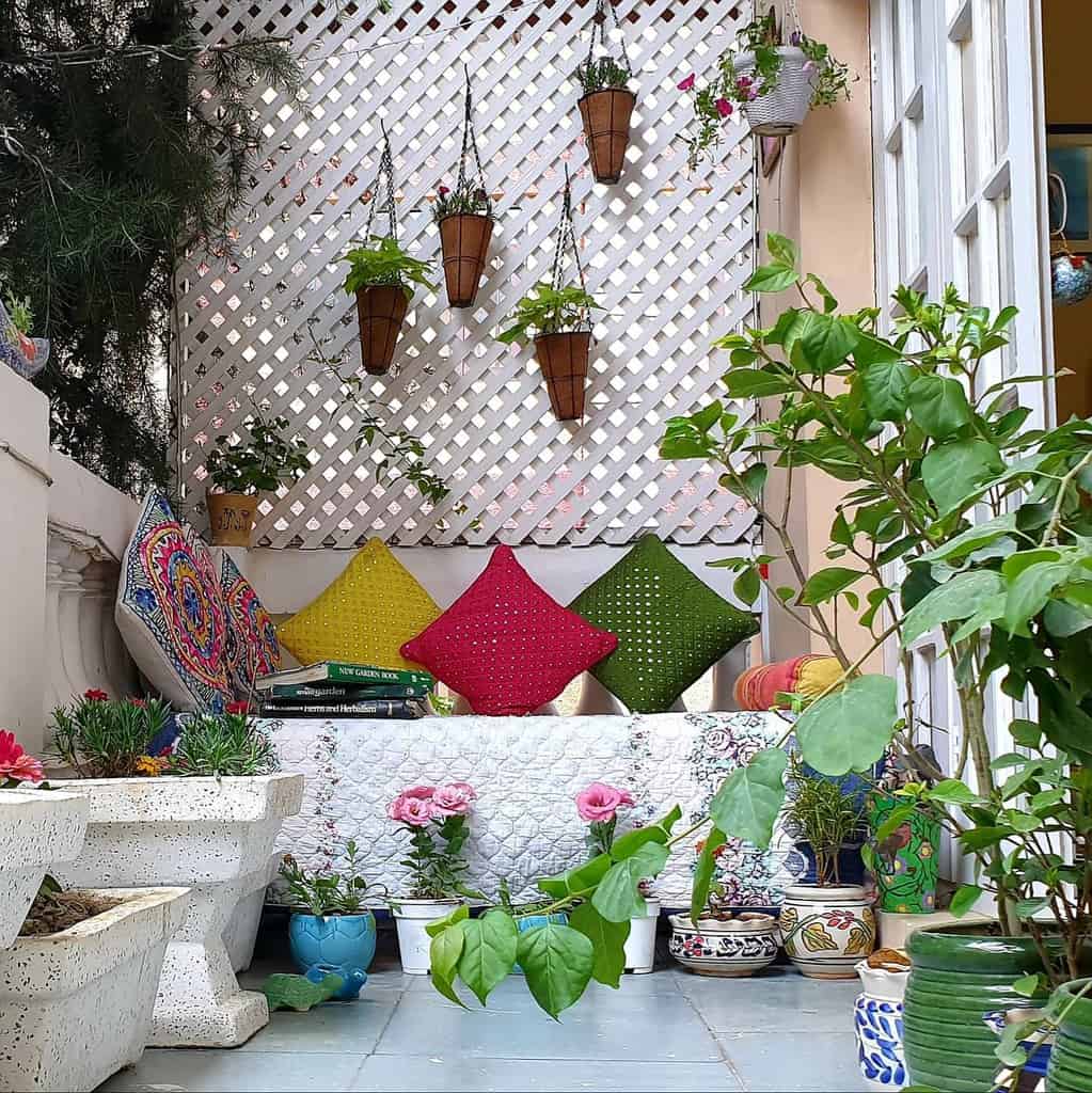 Small patio with seating and colorful cushion plants 