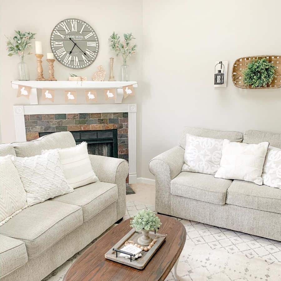 Neutral farmhouse living room with gray sofas and stone fireplace 
