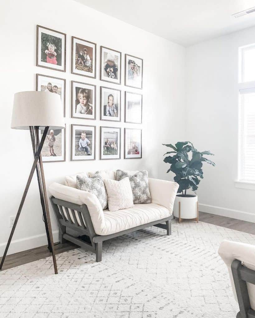 Minimalist white living room with framed children's photos on the wall 