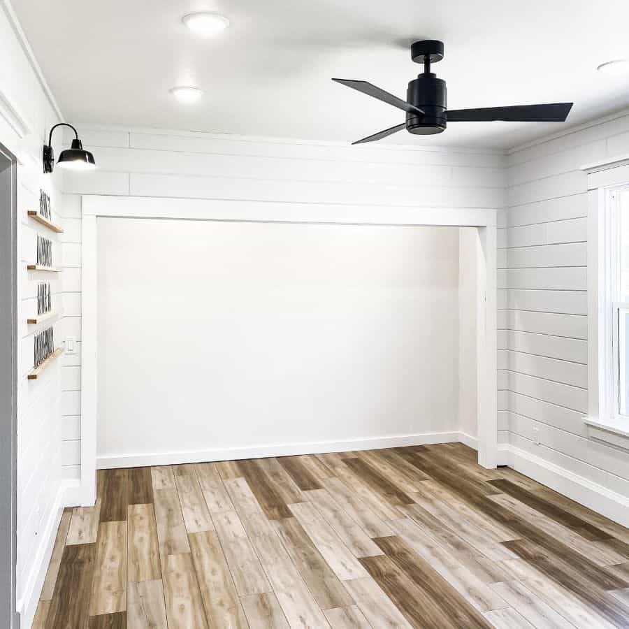 Sparse white wood flooring in guest bedroom with shiplap 