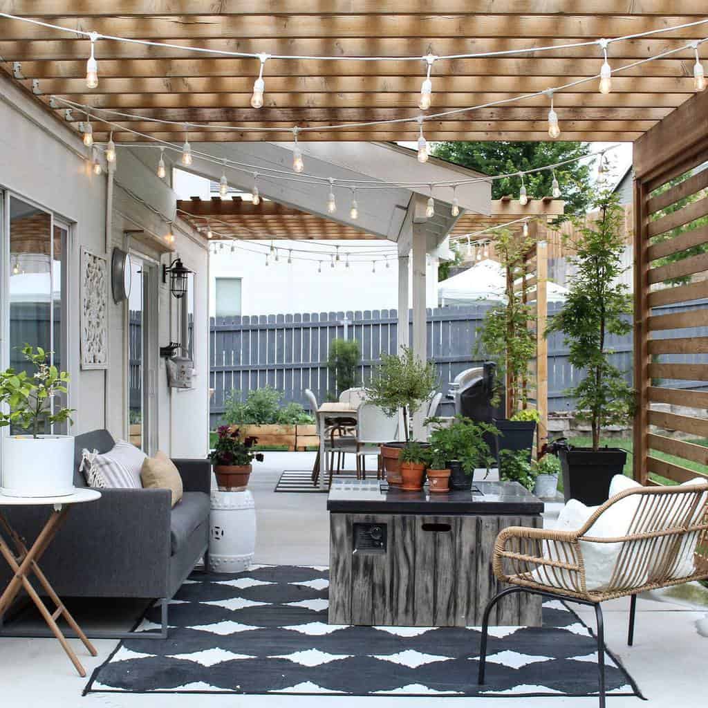 Large backyard patio with wooden pergola and fairy lights