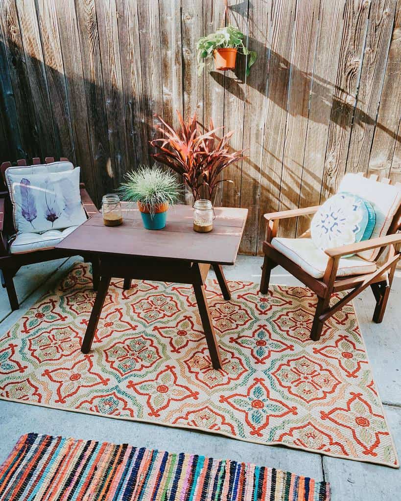 Vintage table and chairs on patterned carpet backyard patio