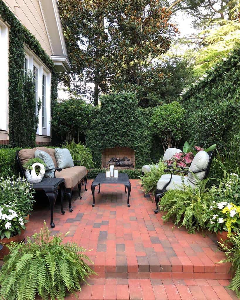 Brick garden terrace with ornate furniture and fireplace