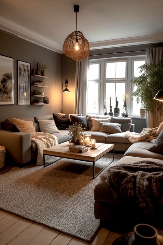 an earthy living room with taupe walls, a gray sofa, some pillows, a coffee table and open shelves