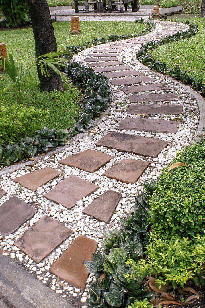 Create a whimsical pathway using stones or bricks to guide visitors through your backyard