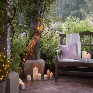 Layer lighting options, including lanterns ​and sconces, in your small patio design