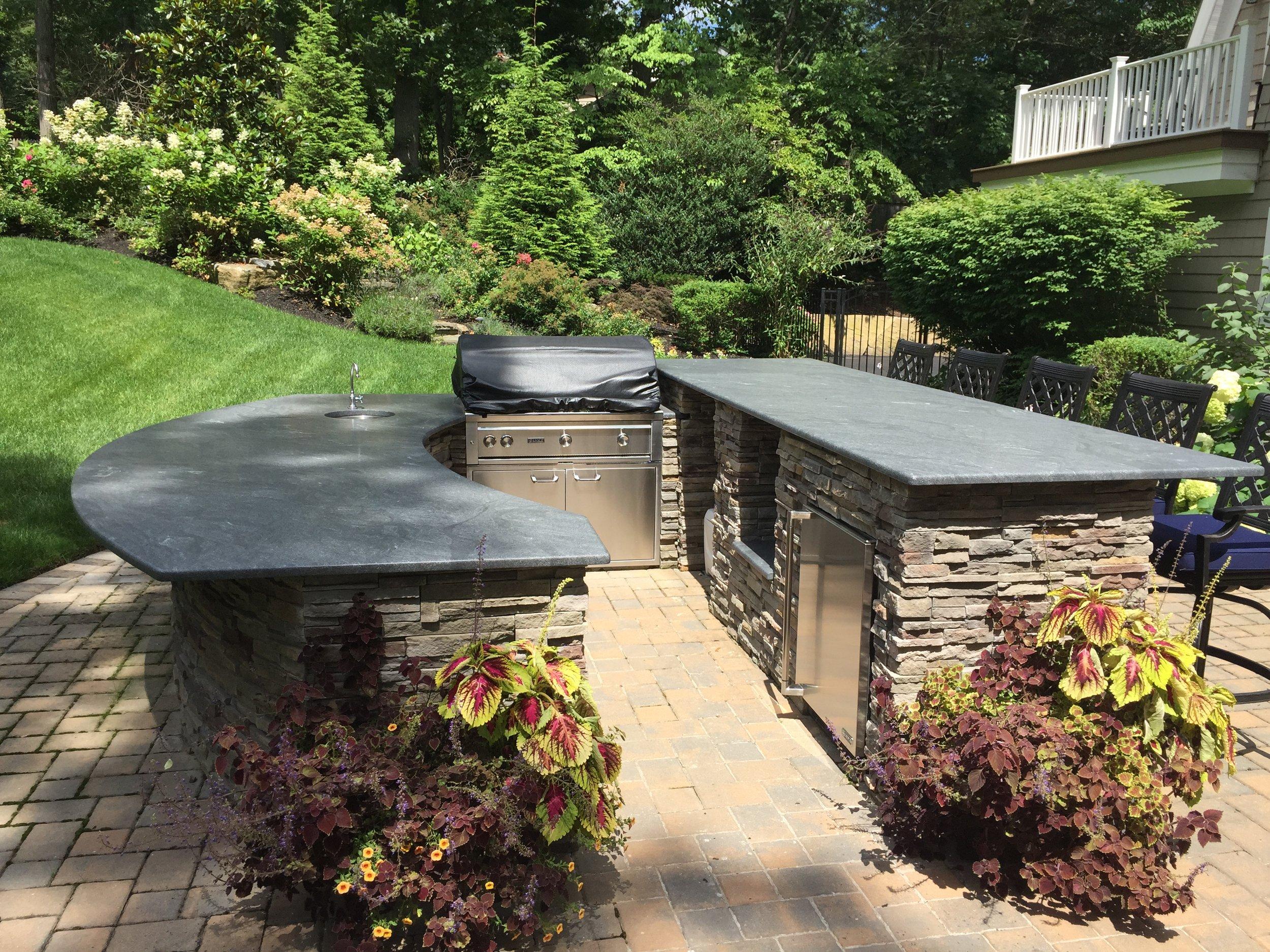 Design an outdoor kitchen to merge functionality with aesthetics in landscaping design