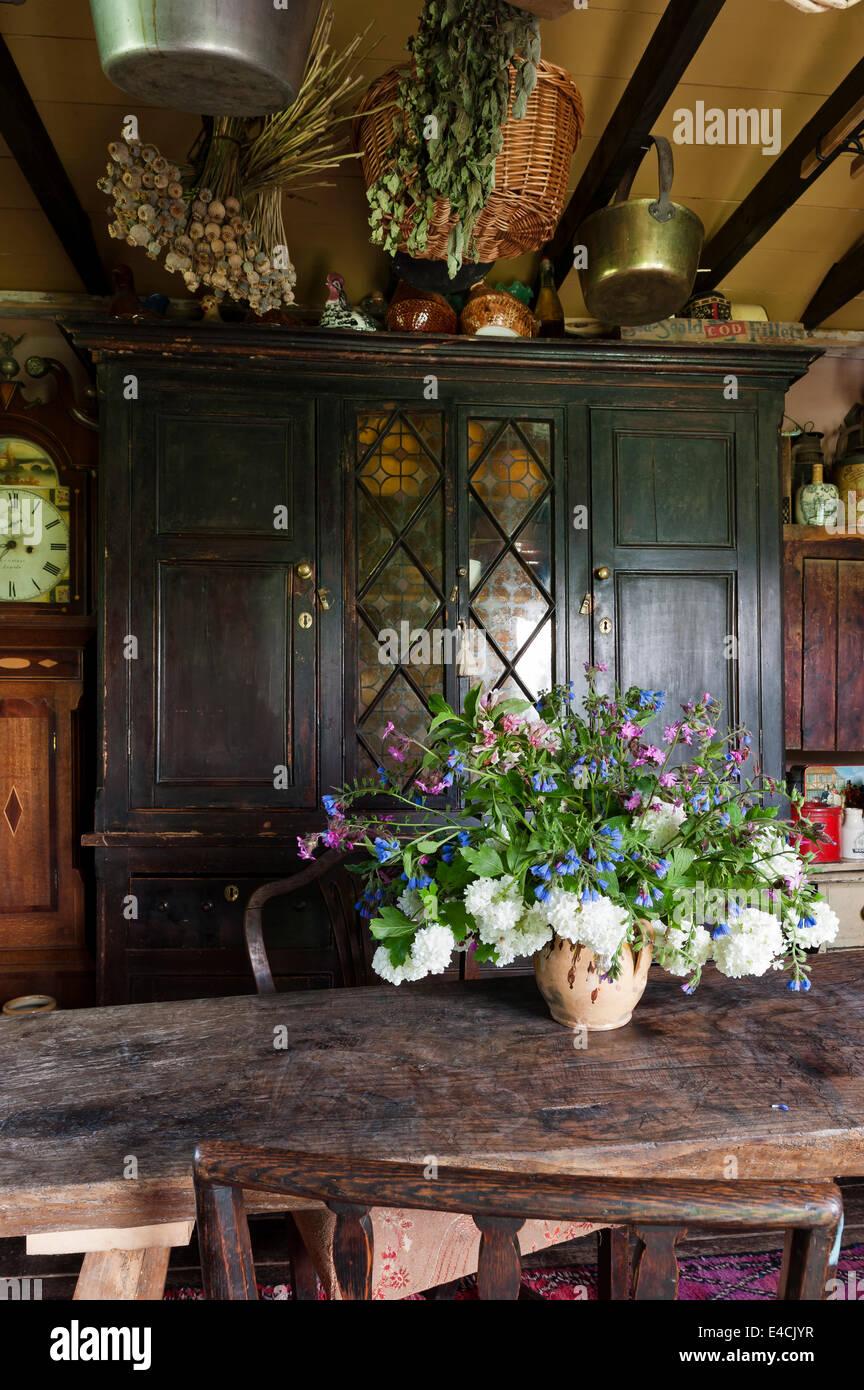 Fresh flowers on the table brighten the ambiance of ‌your country kitchen