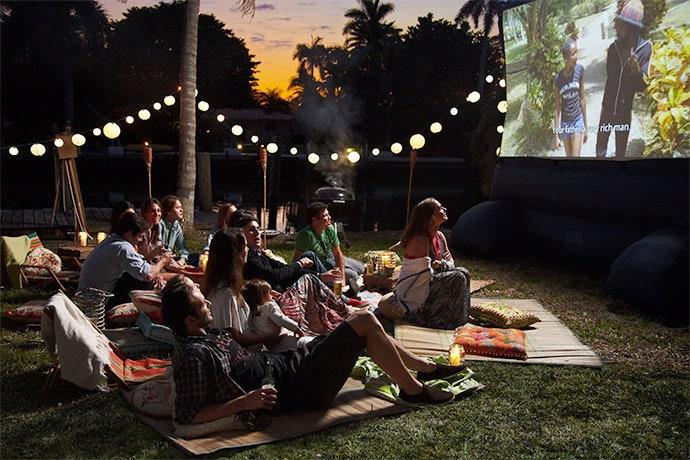 Incorporate an outdoor movie setup for entertainment in your modern backyard