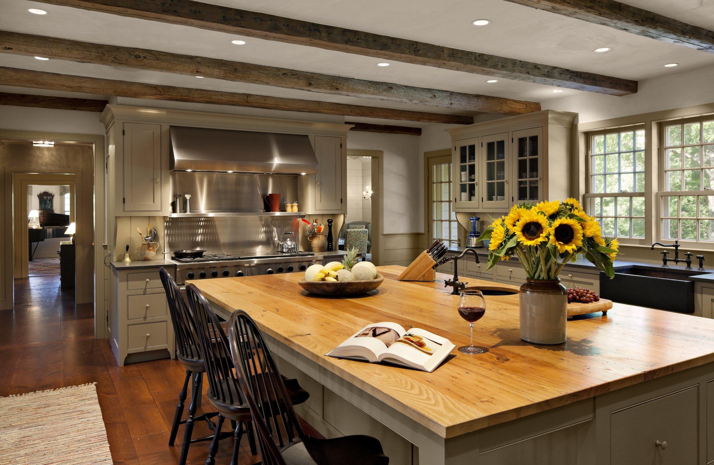 A large kitchen table fosters family gatherings in a cozy country kitchen