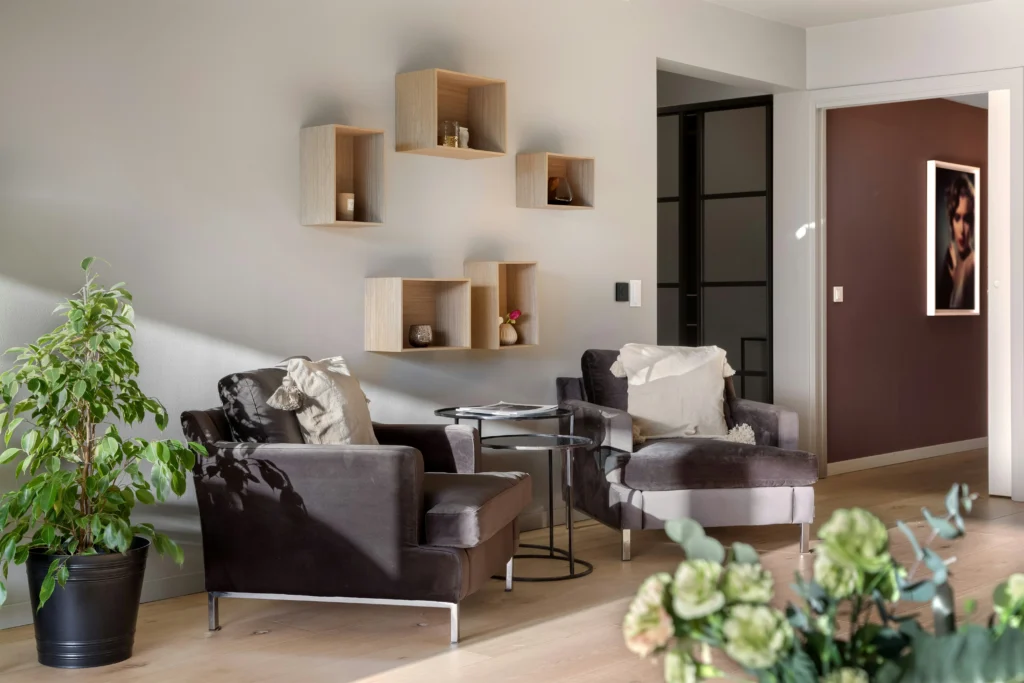 Minimalist modern living room with wall shelves and plush armchairs