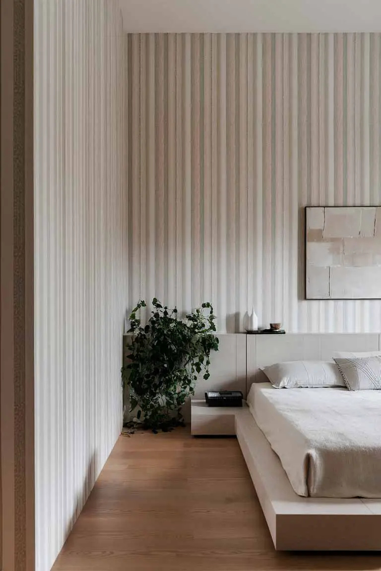 Small bedroom with vertical striped wallpaper in neutral tones and minimalist decor