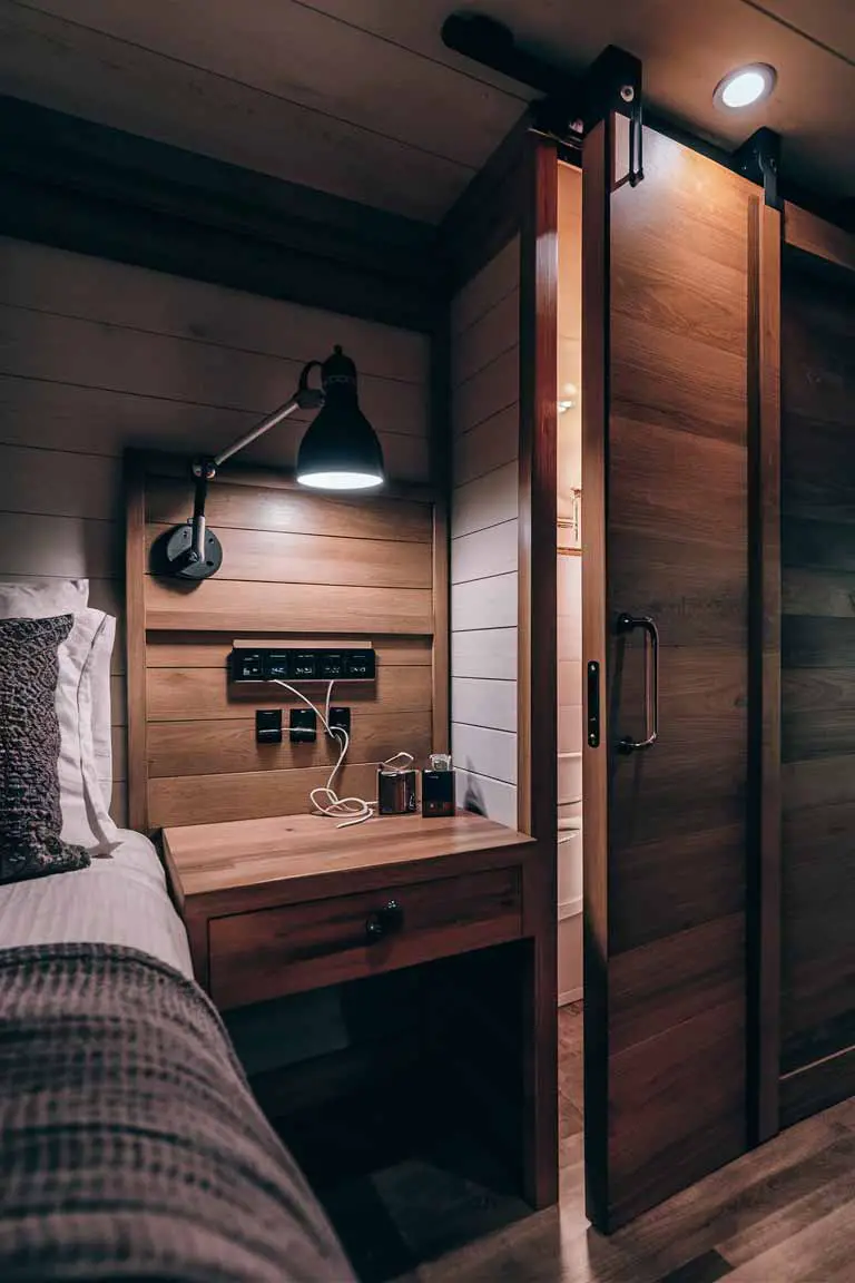 Nightstand with built-in charging ports, adjustable lamp, and sliding door in tiny bedroom