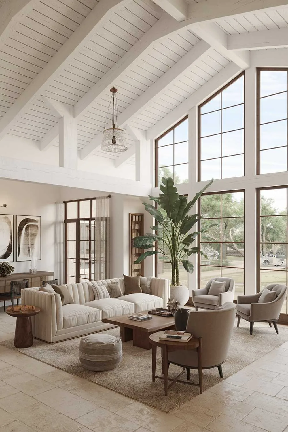 Modern farmhouse living room with white wooden beam ceiling, large windows, plush beige sofa, chairs, wooden coffee table, large plant, artwork, and beige tile floor.