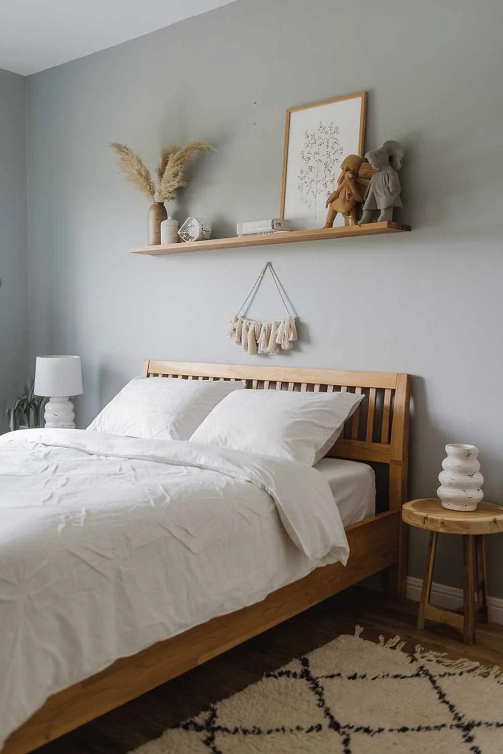Scandinavian farmhouse bedroom with wooden bed, white duvet, wooden shelf, and light blue walls.