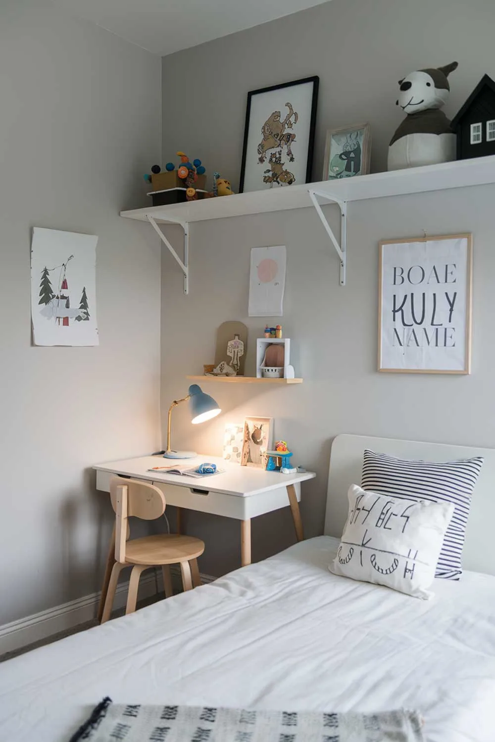 Minimalist kids bedroom with white bed, light gray walls, and small study desk