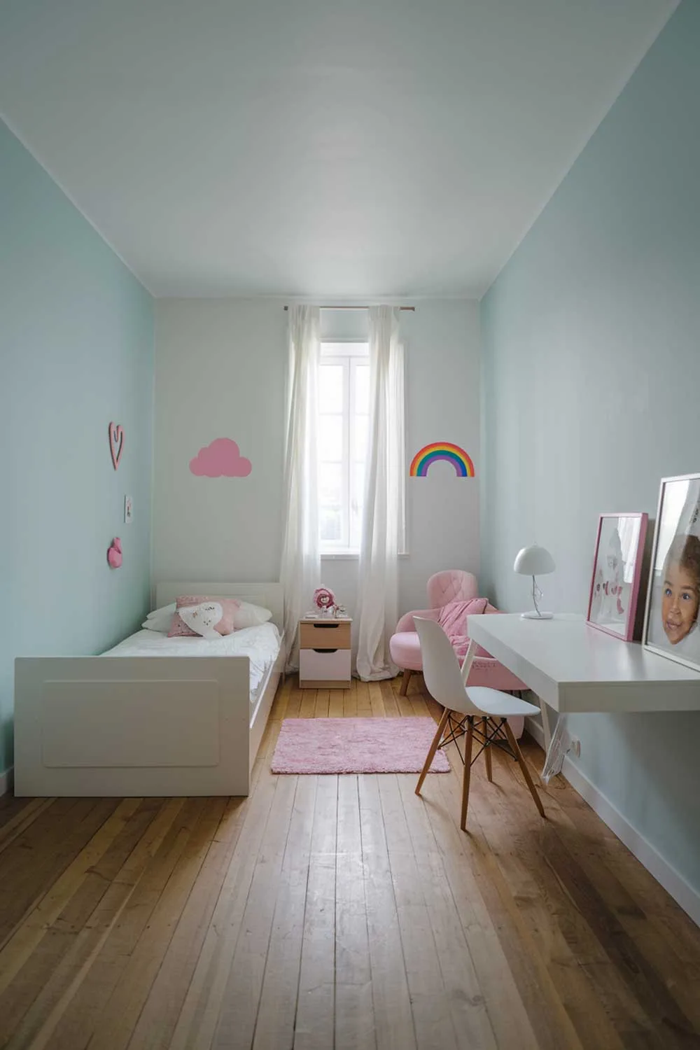 Minimalist girls bedroom with soft blue walls and pink accents
