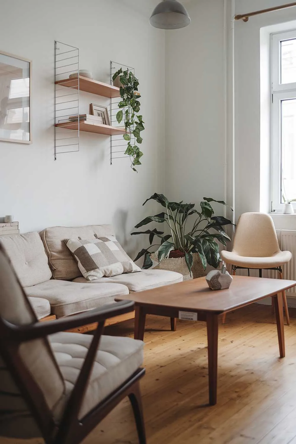 Small Scandinavian living room with beige sofa, wooden coffee table, floating shelf, and plants