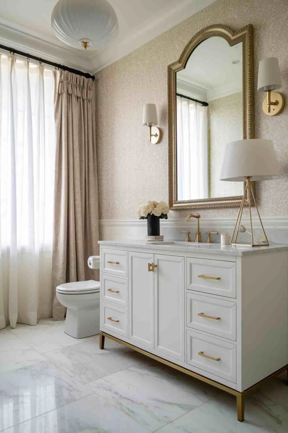 Bathroom featuring gold hardware, marble countertop, and patterned wallpaper