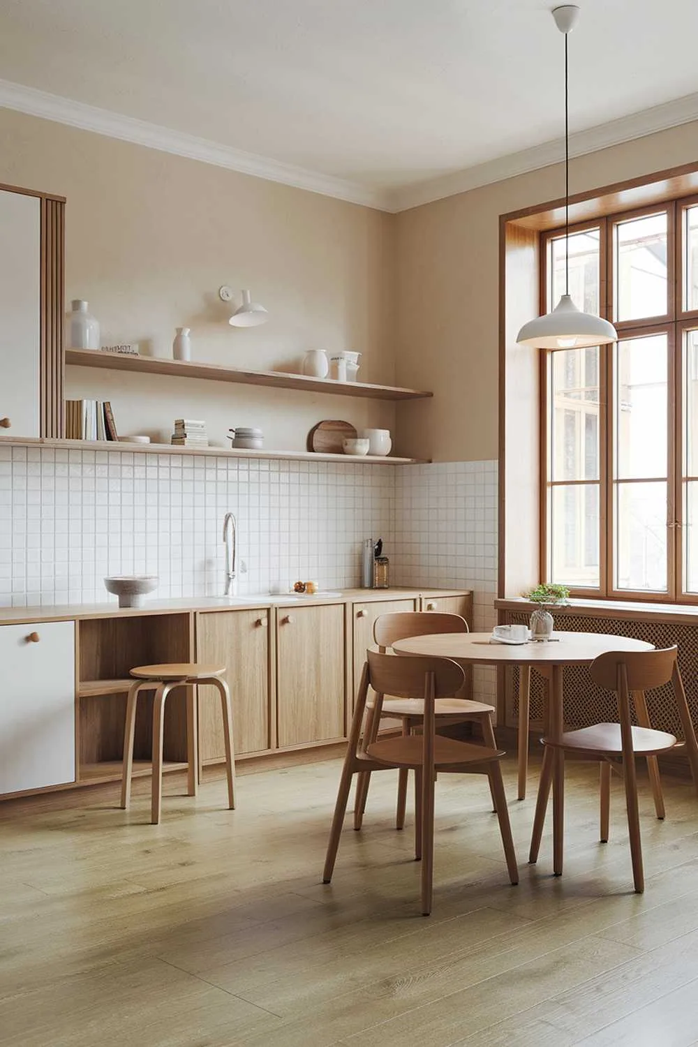 Scandinavian kitchen with corner wooden dining table, white cabinets, and pendant lighting
