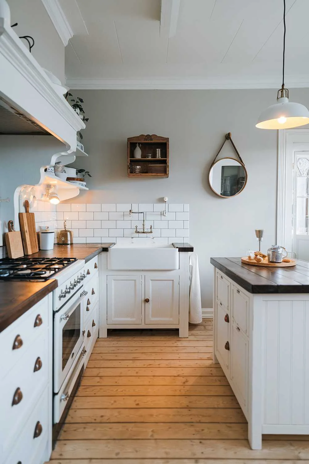Scandinavian kitchen with light wood floor, white cabinets, dark wood countertop, and decorative elements