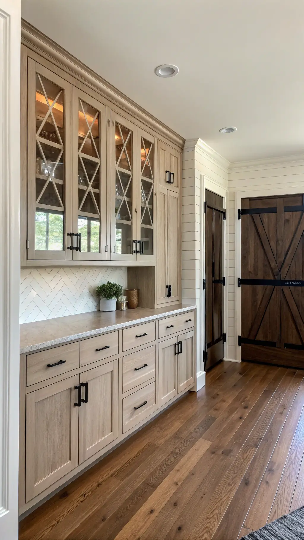 modern farmhouse kitchen with warm greige shaker cabinets walnut lower and glass-front upper with x-mullions under bright midday lighting
