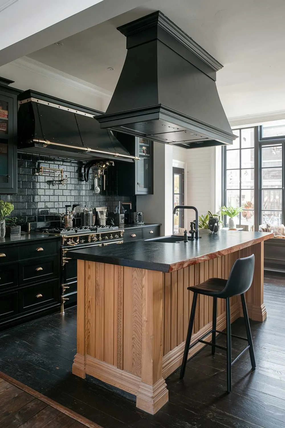 Modern kitchen with black countertops, wooden island, black range hood, and dark wood flooring