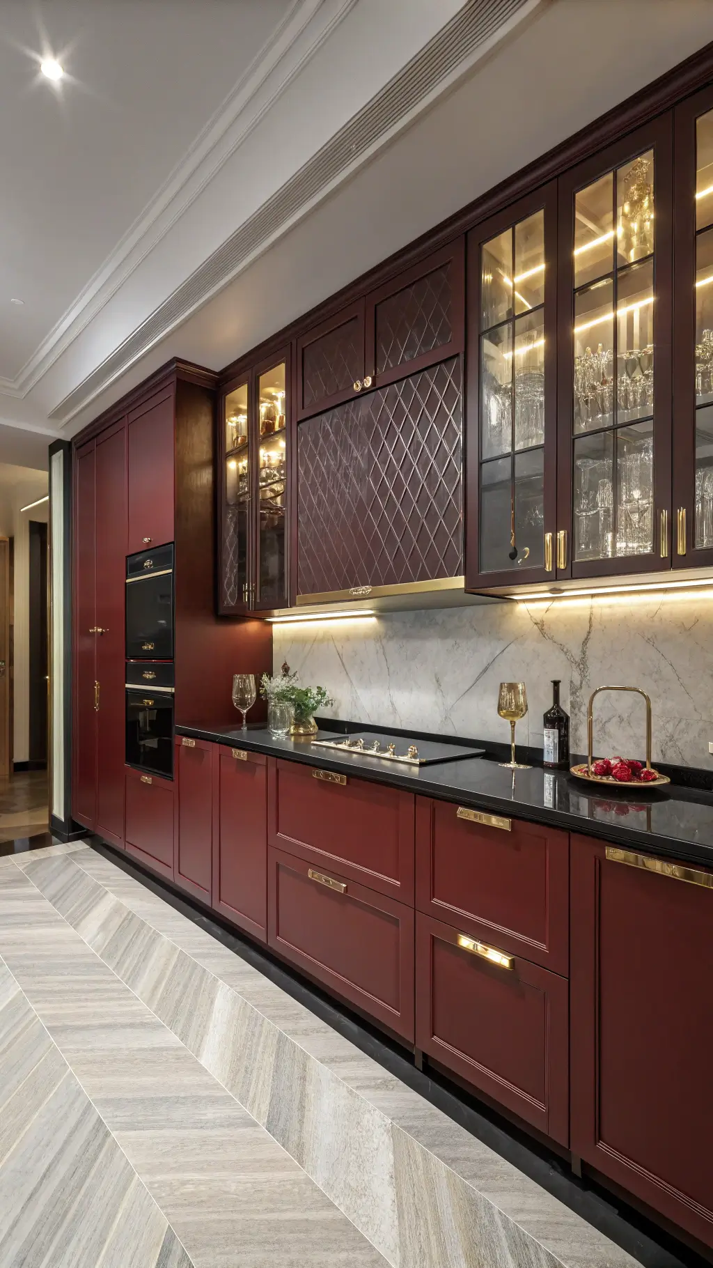 Luxurious art deco kitchen with wine red lacquered cabinets, brass hardware, and black granite countertops