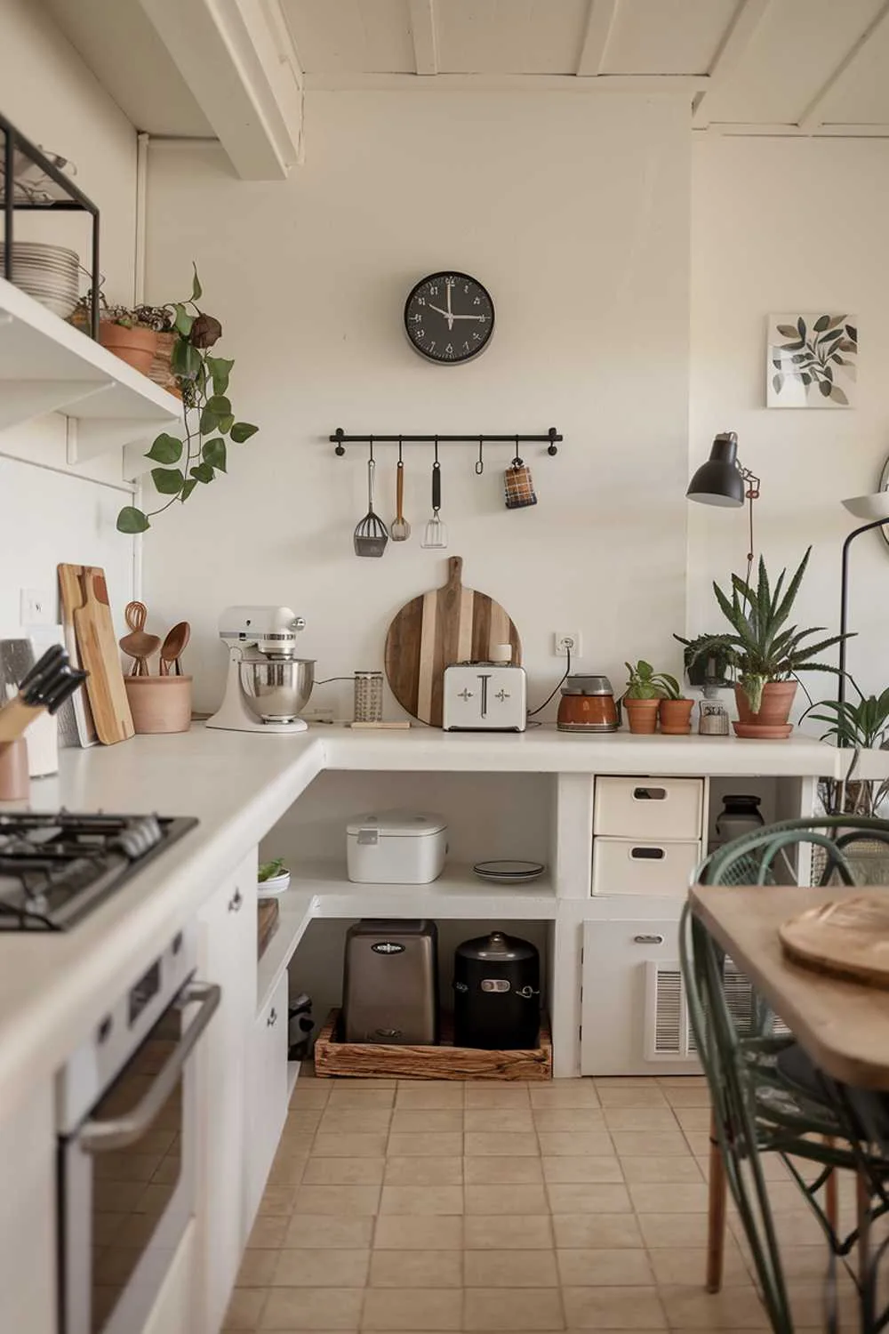 Minimalist kitchen with white countertops, black clock, and organized hooks