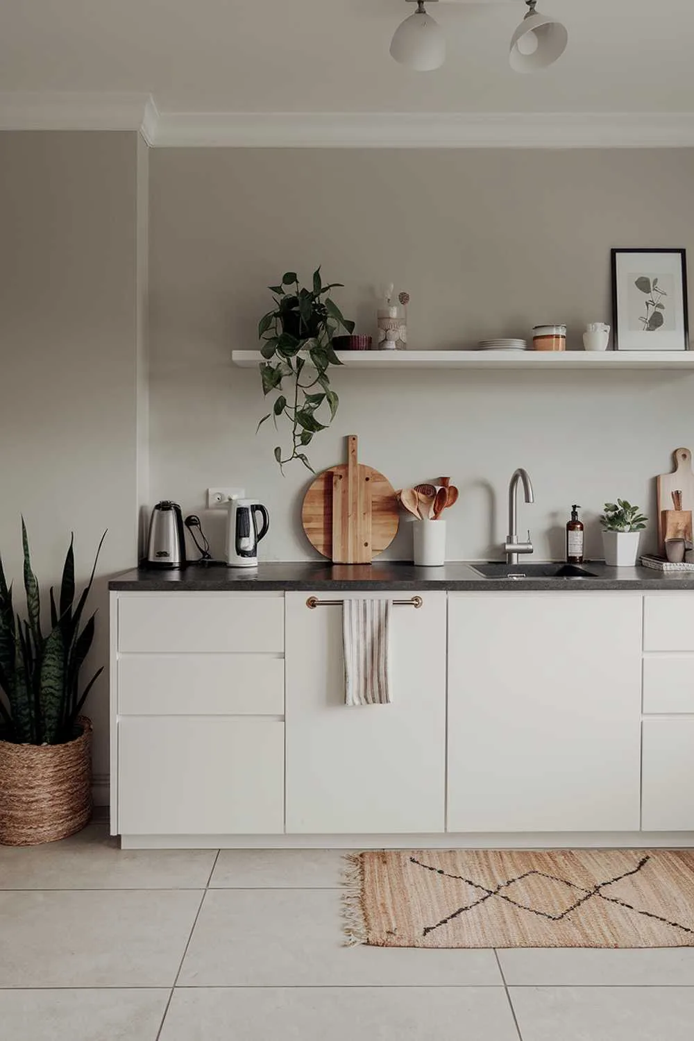 Minimalist kitchen with black countertop, wooden cutting board, and soft lighting
