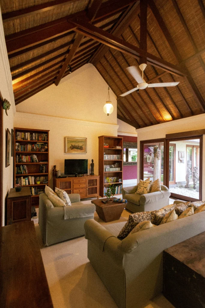Bali Style Living Room with Thatched Ceiling and Dark Wood Shelves
