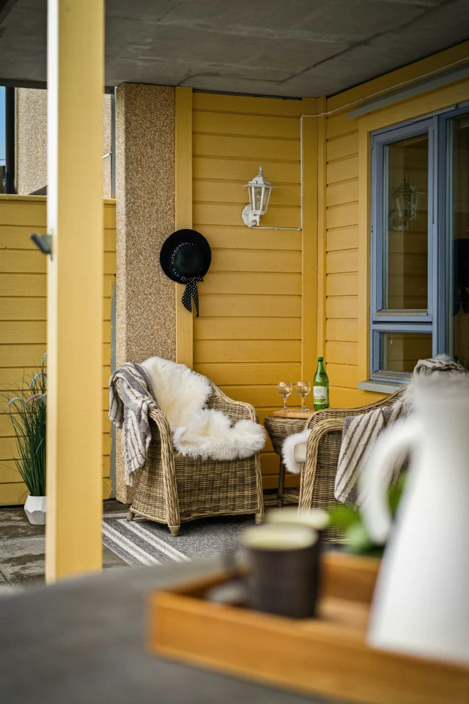 Bright yellow wall with wicker chairs and cozy throws