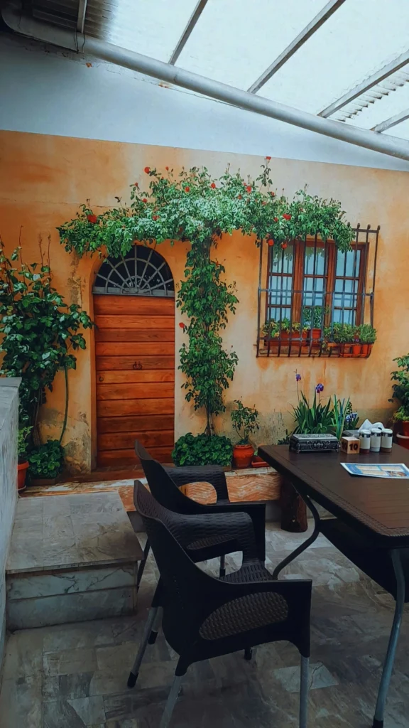 Rust-colored wall with wooden door and climbing vines