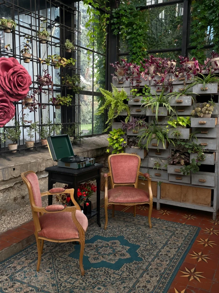 Vintage velvet chairs with wall of drawers filled with plants