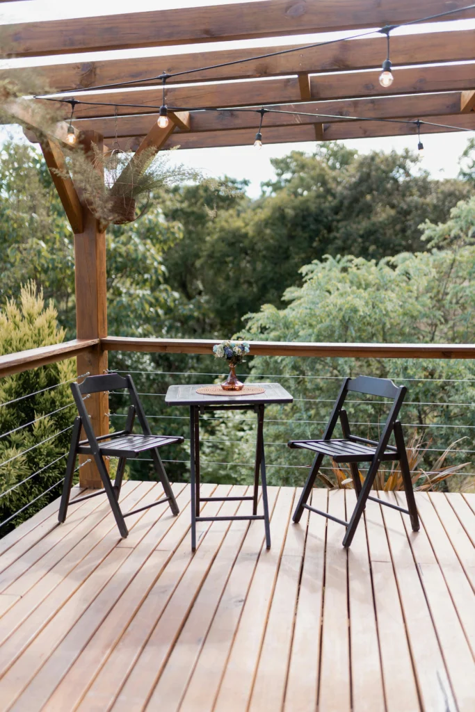 Wood deck with black bistro set and string lights